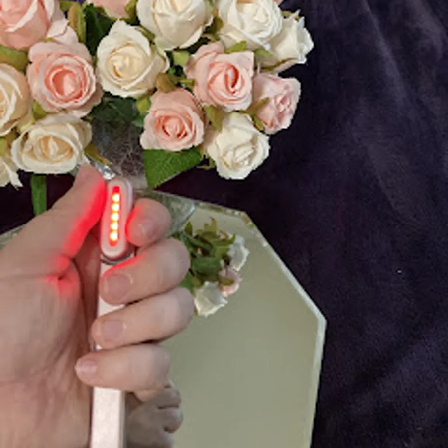 Customer holding her Flarelit Glow Wand in front of fresh flowers